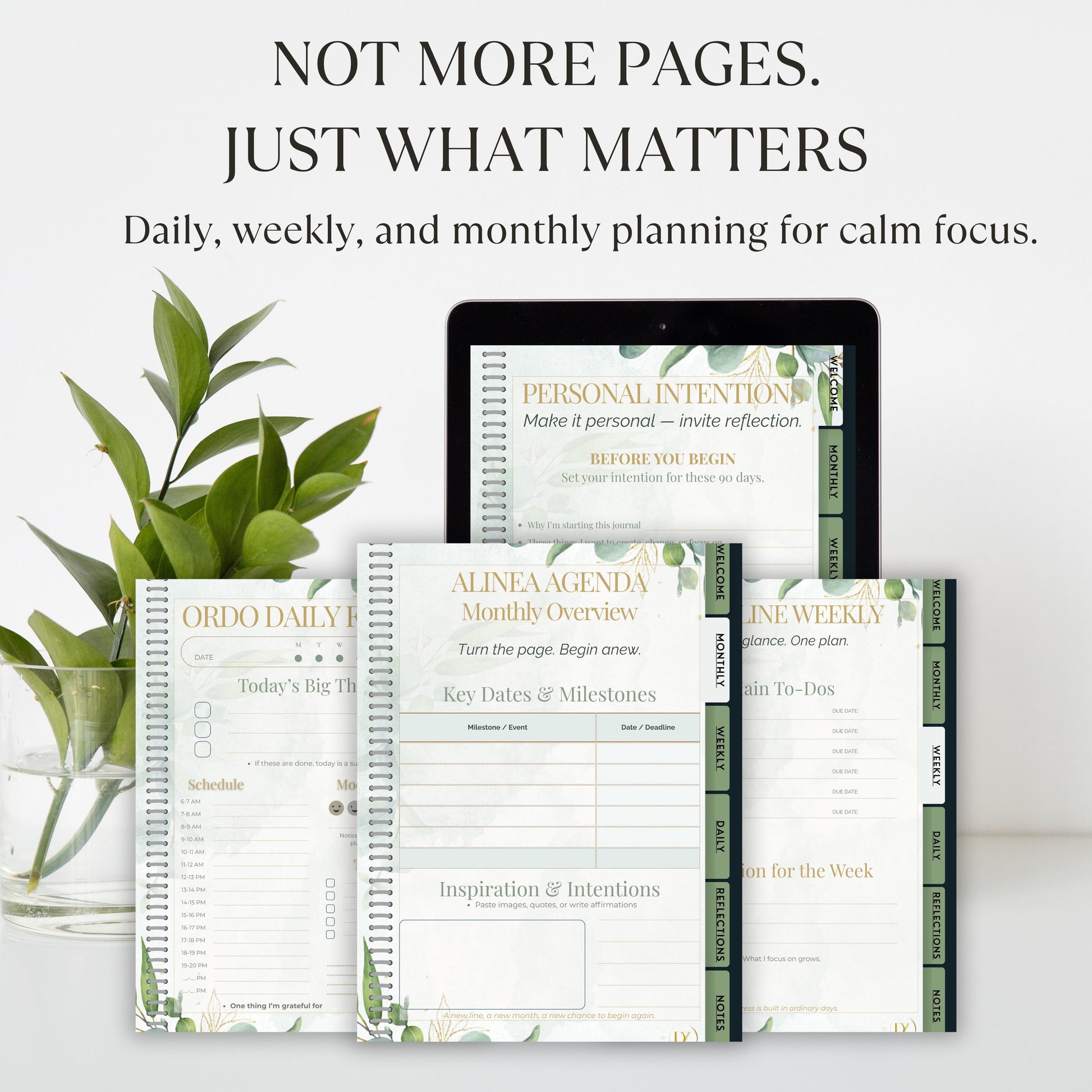 Planners and a tablet with planning software on a white surface with greenery.