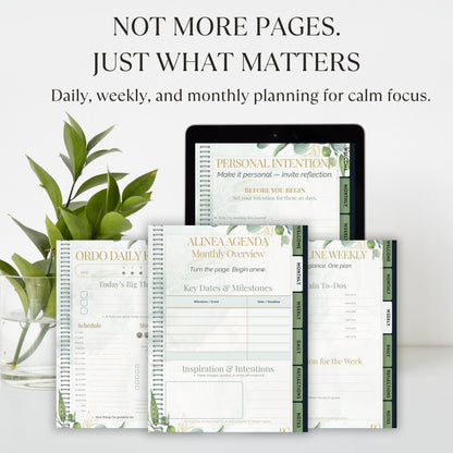 Planners and a tablet with planning software on a white surface with greenery.