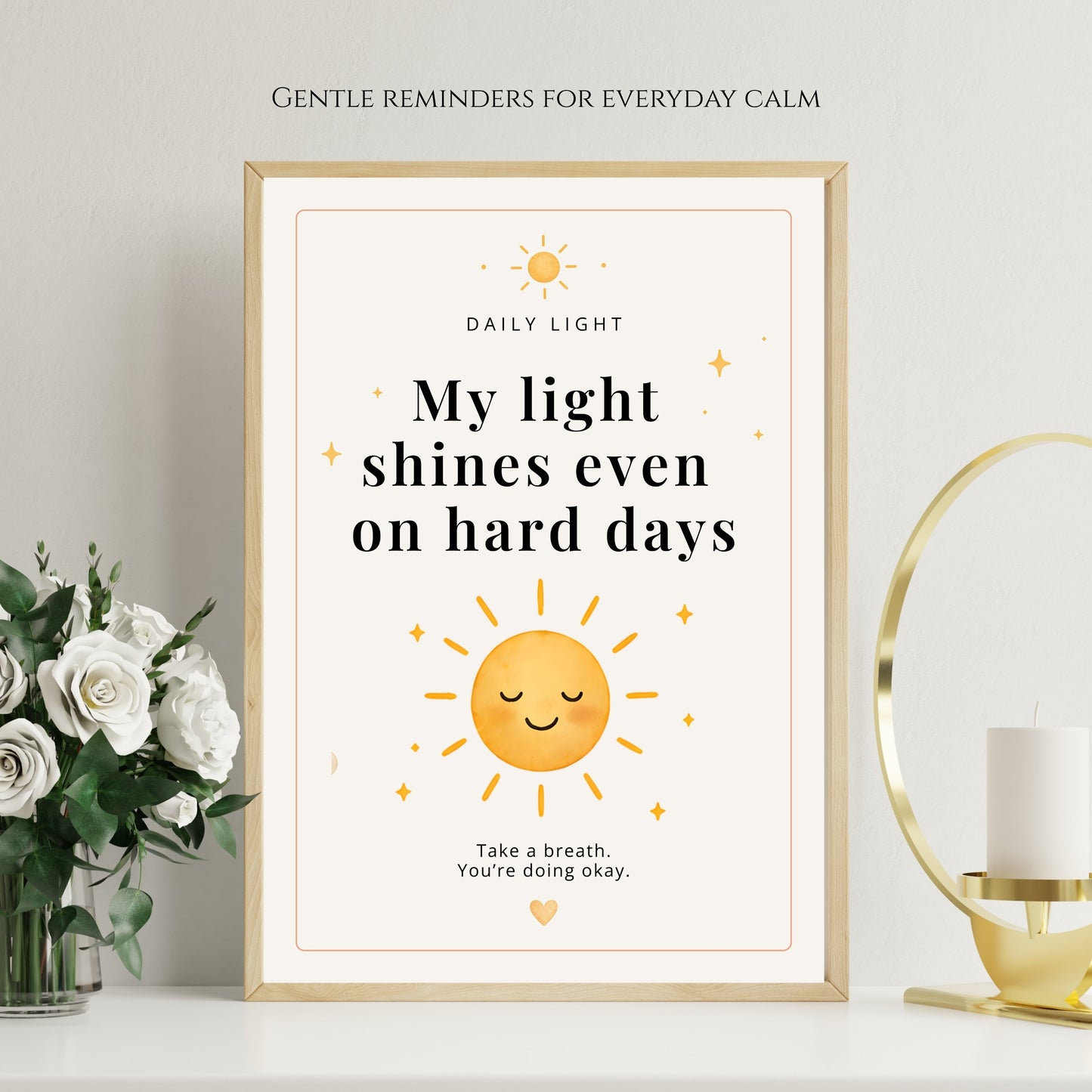 Framed motivational poster with sun illustration and text on a wall with decor elements.