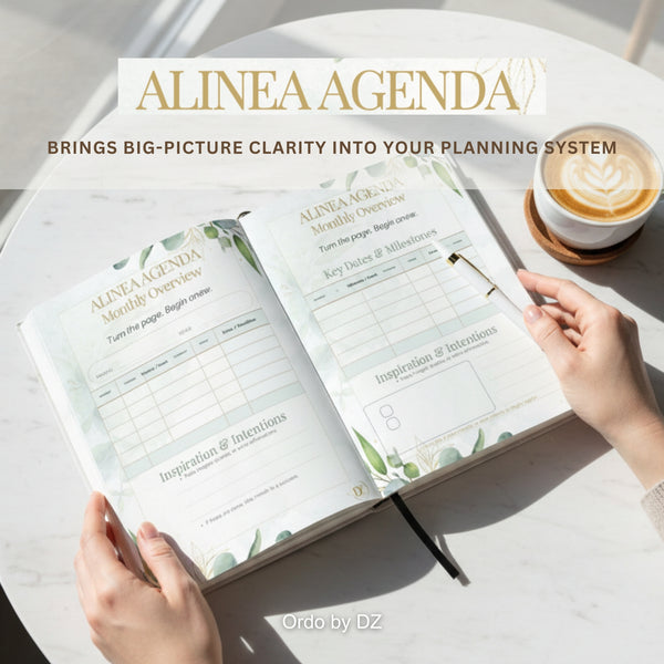 Ordo Alinea Agenda planner with hands holding it on a table with a cup of coffee. Front pages
